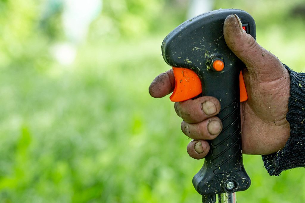 Close-up of a man pushing the mower button
