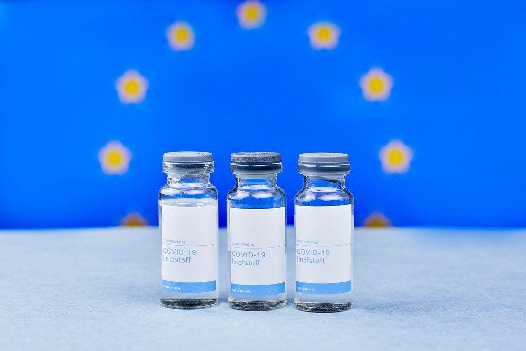 Close-up of Covid-19 vaccine doses against flag of European Union