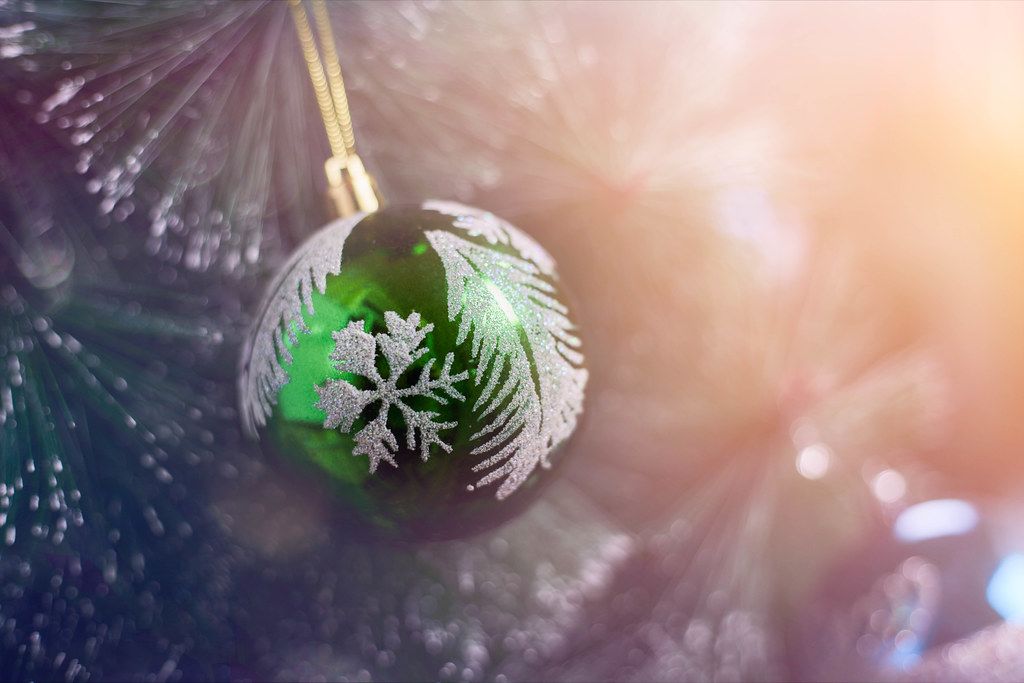 Close-up shot of green Christmas ball hanged on a tree