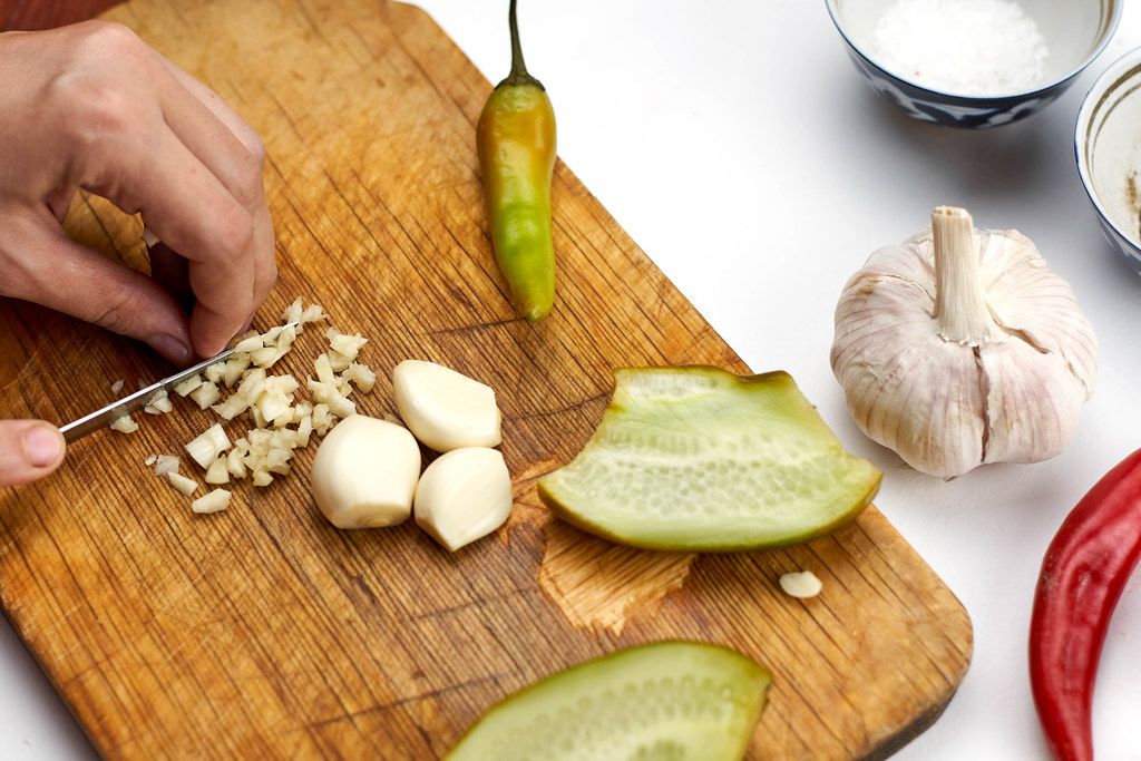 Close-up shot of woman cutting garlic