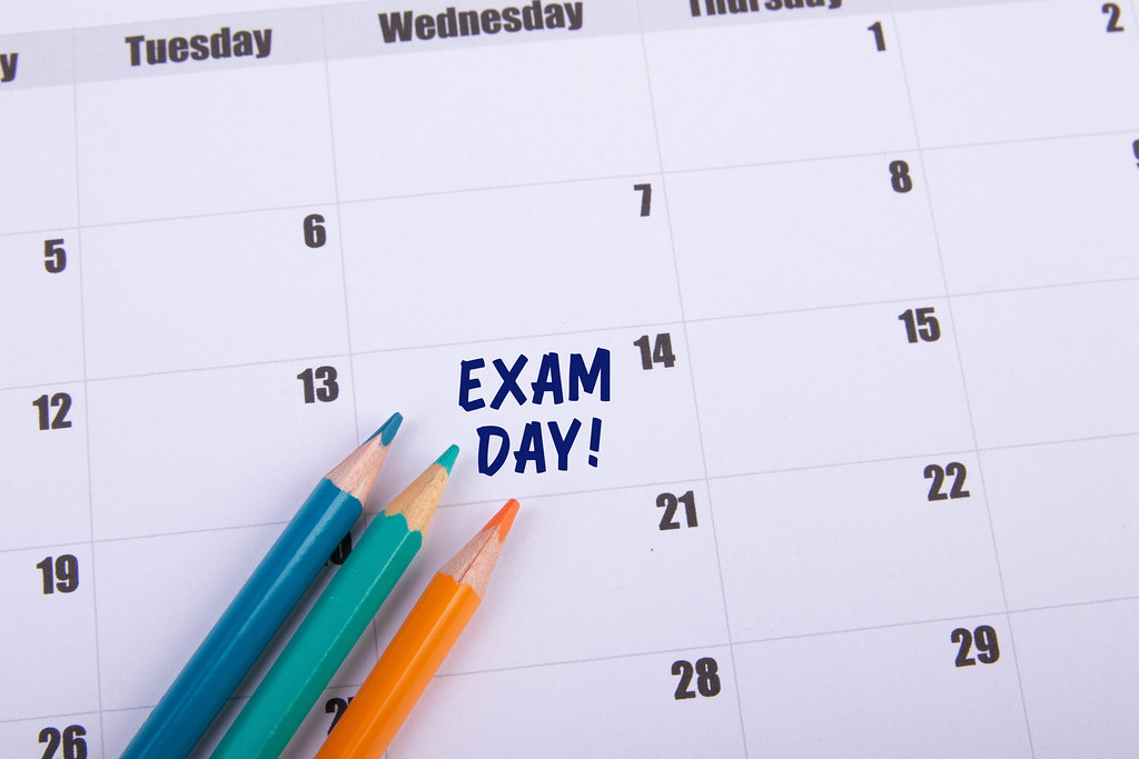 Colored pencils with Exam Day text on the calendar