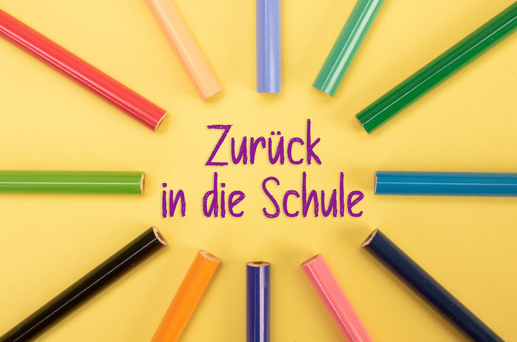 Colored pencils with Zurück in die Schule text on yellow backgorund