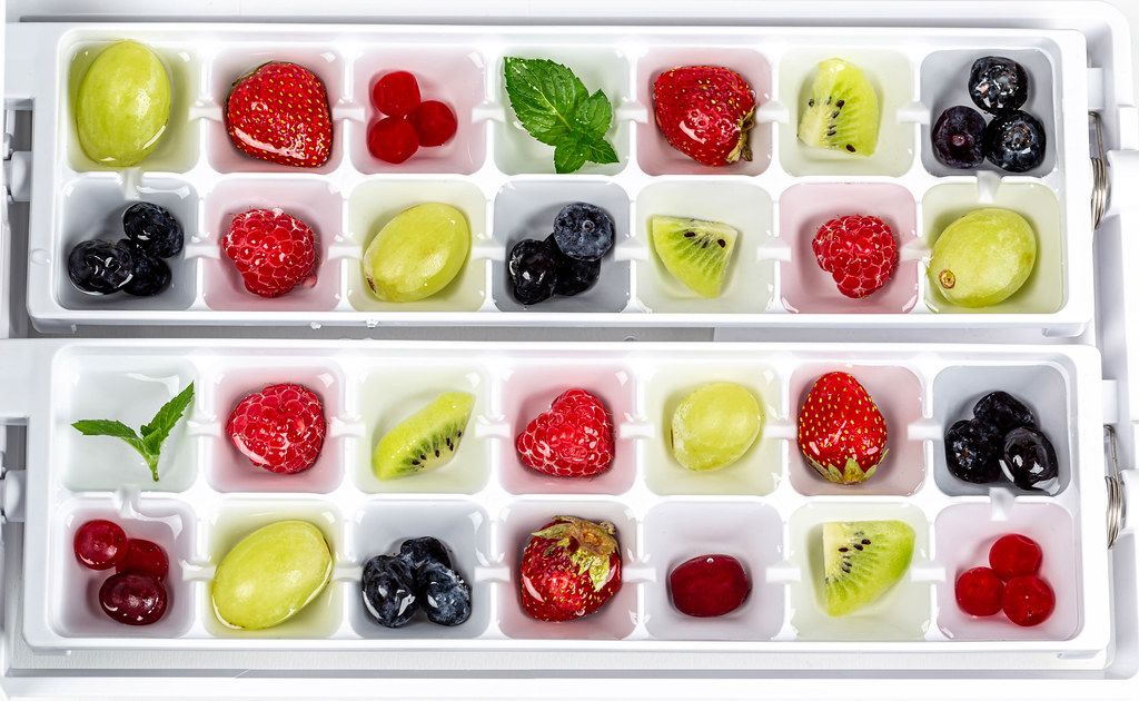 Colorful berries, fruits and mint are prepared for freezing fruit ice