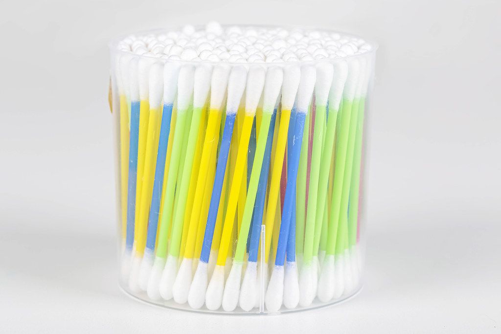 Colorful cotton swabs on light background