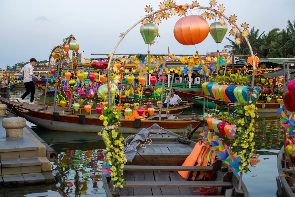 Colorful Lanterns and Flowers attached to Wooden Rowing Boats for Tourists to take a Boat Ride in the Ancient Town of Hoi An, Vietnam