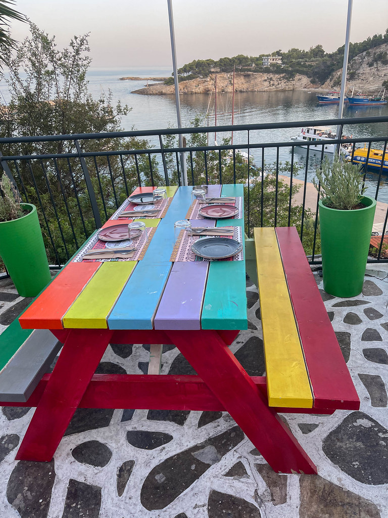 Colourful wooden table at Favela restaurant with sea view above the seafront of Patitiri, Alonissos