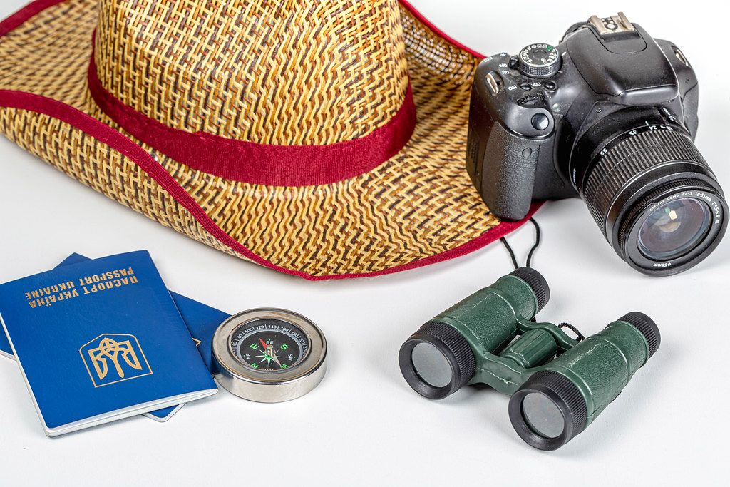 Compass, binoculars, hat, camera and passports - tourism concept