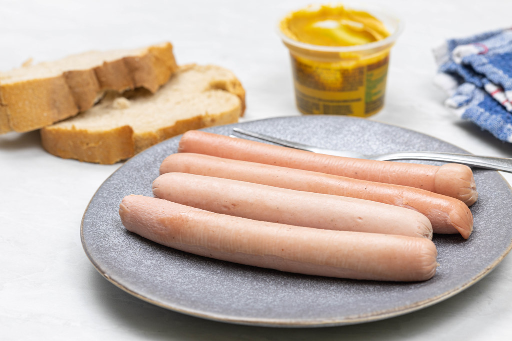 Cooked Hot Dogs served on the plate with Mustard