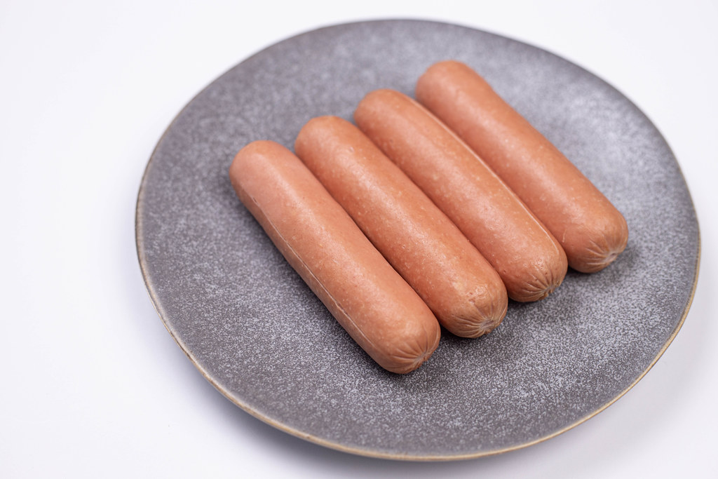 Cooked Hotdogs served on the plate above white background