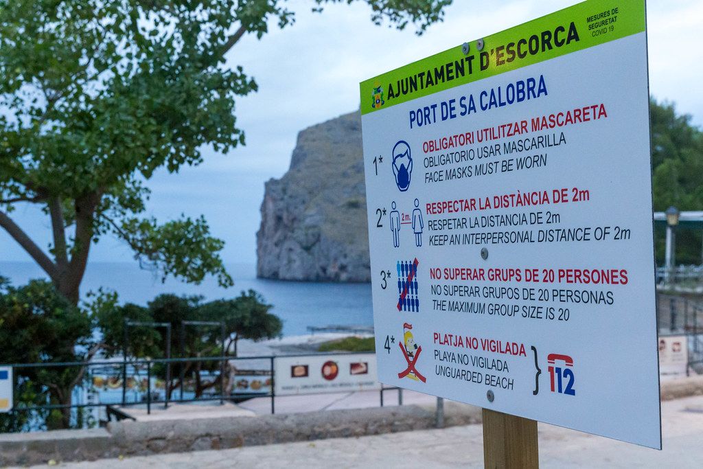 Corona-Regeln für Touristen und Locals auf einem Schild in Port de Sa Calobra, Mallorca, Spanien