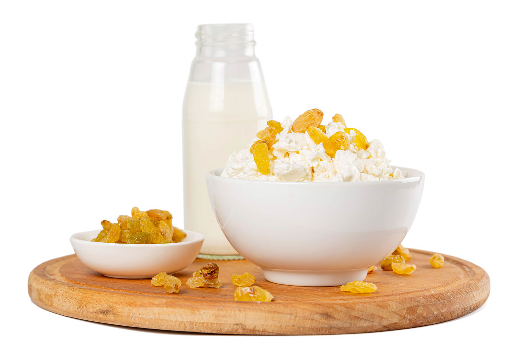 Cottage cheese with raisins and milk in bottle, healthy food concept