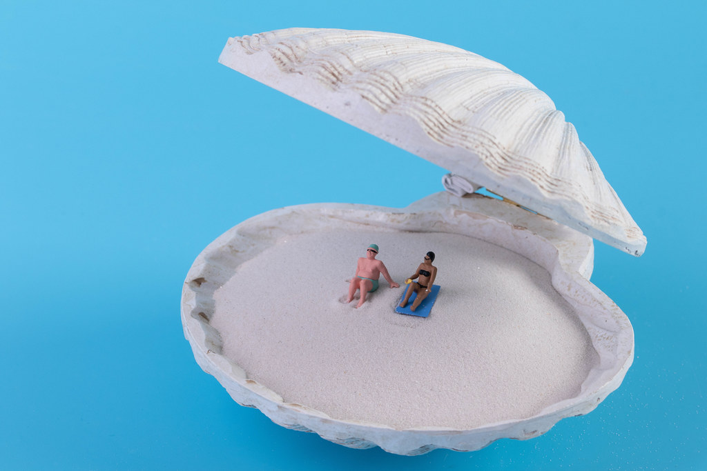 Couple relaxing on the sand in the seashell