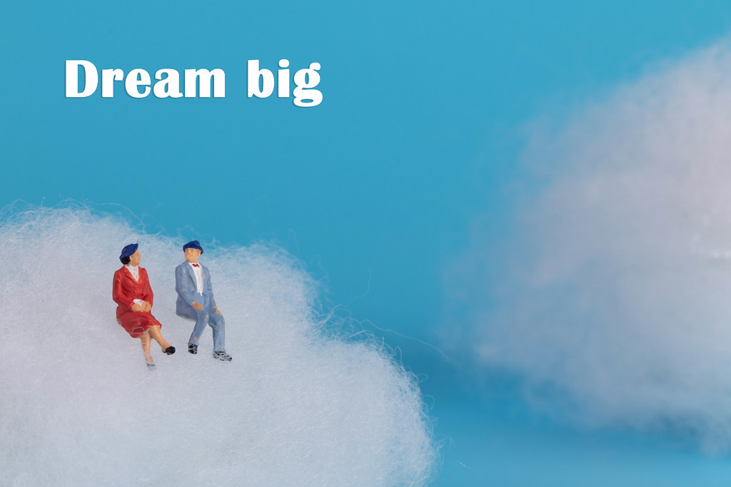 Couple sitting on a cloud with Dream Big text