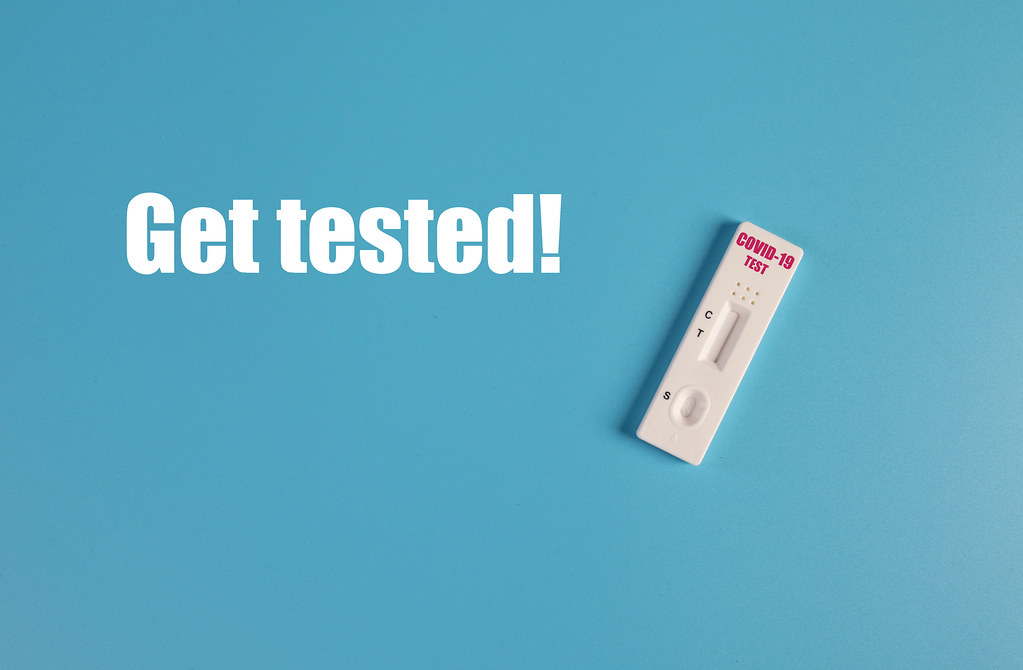 Covid-19 rapid antigen test with Get tested! text on blue background