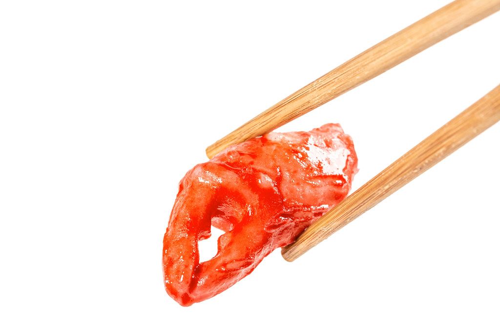 Crab claw on a white background with chopsticks