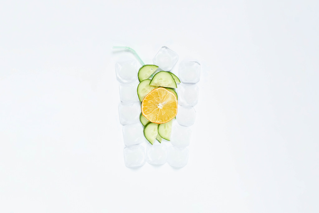 Creative summer drink shape made of ice cubes, cucumber and lemon slices