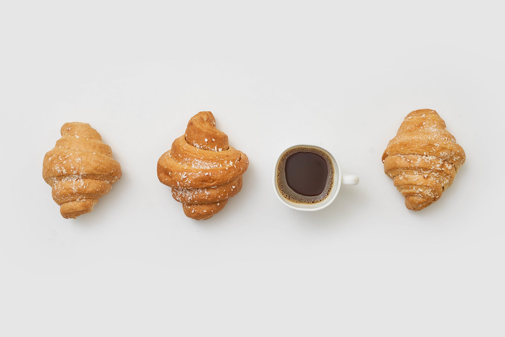 Croissants and a cup of coffee on white background