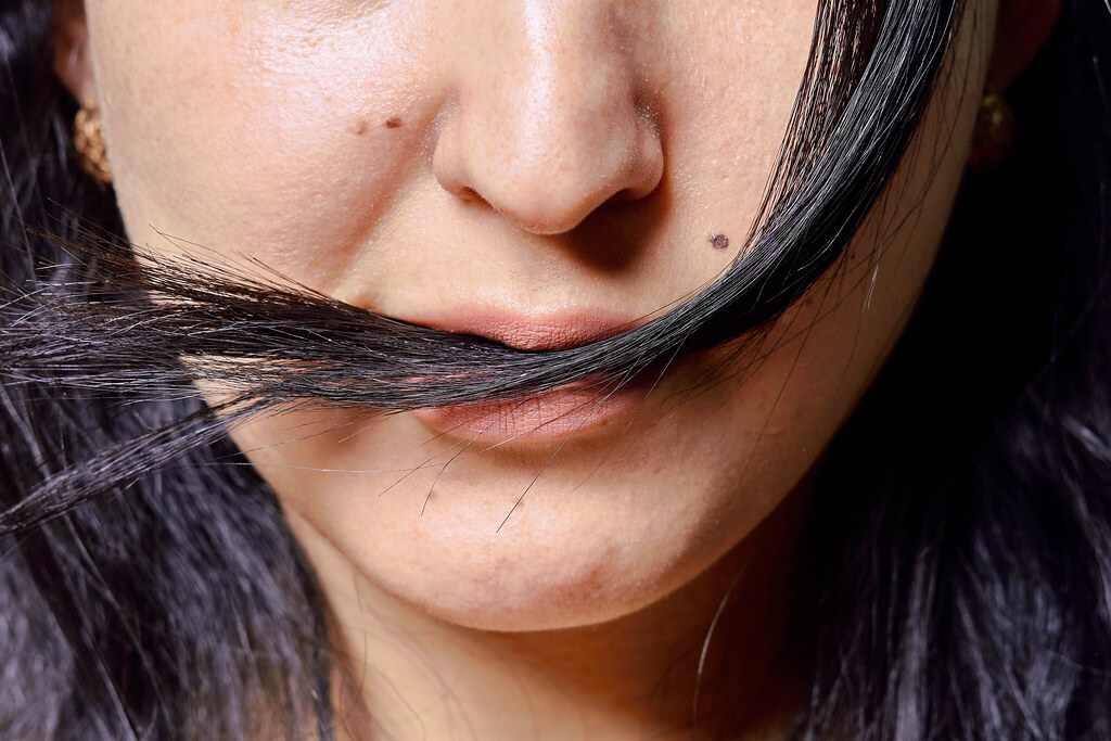 Cropped shot of a woman biting her hairs