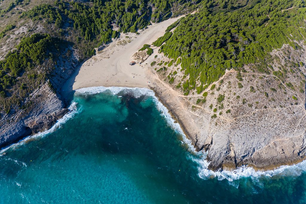 Crystal-clear waters at the bay of Cala Torta, Artà, Majorca. Empty beach in summer 2020. Drone photo