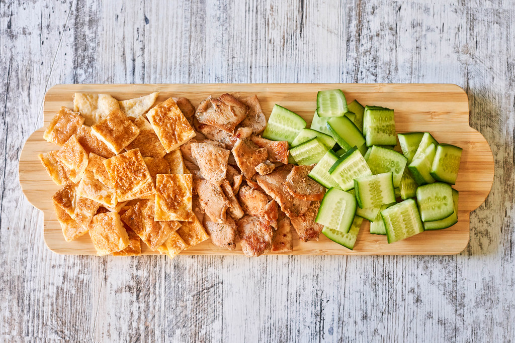 Cucumber, chicken meat and egg omelet cuts on wooden plate
