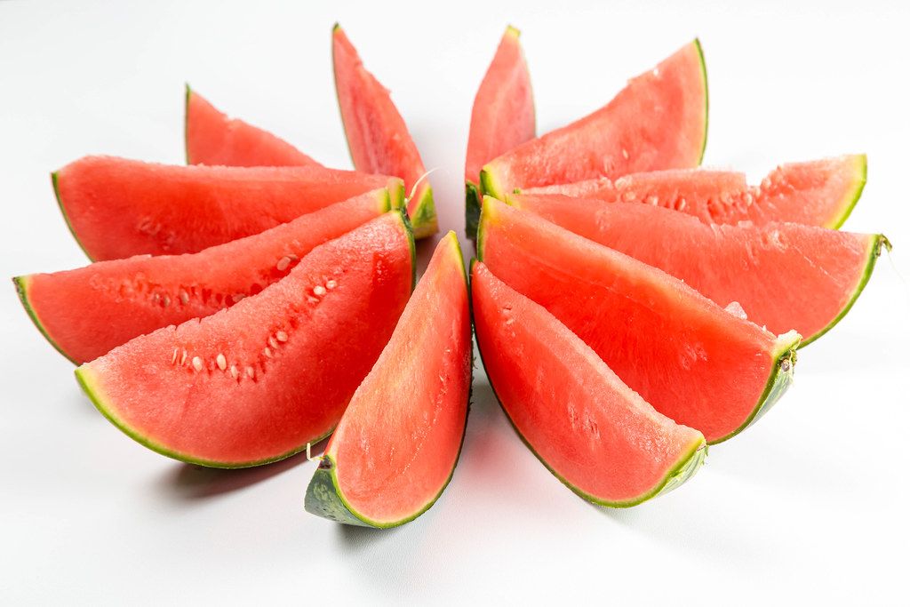Cut pieces of fresh red watermelon on a white background