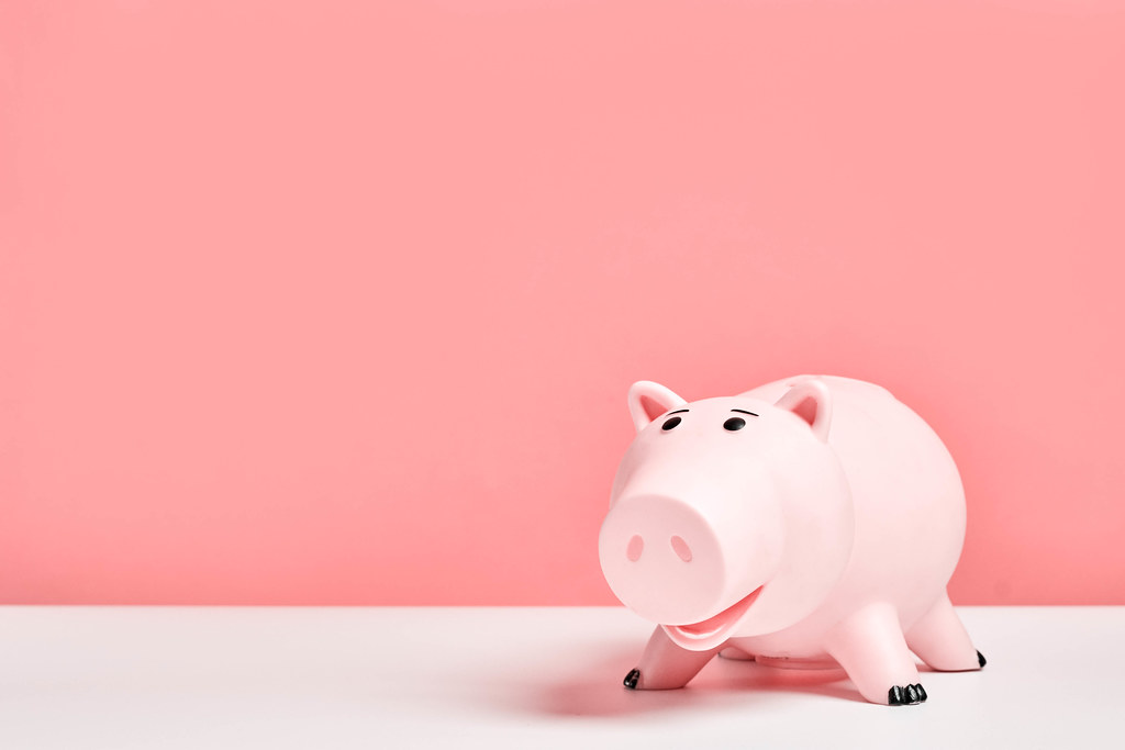 Cute pink piggy bank against the pink colored background