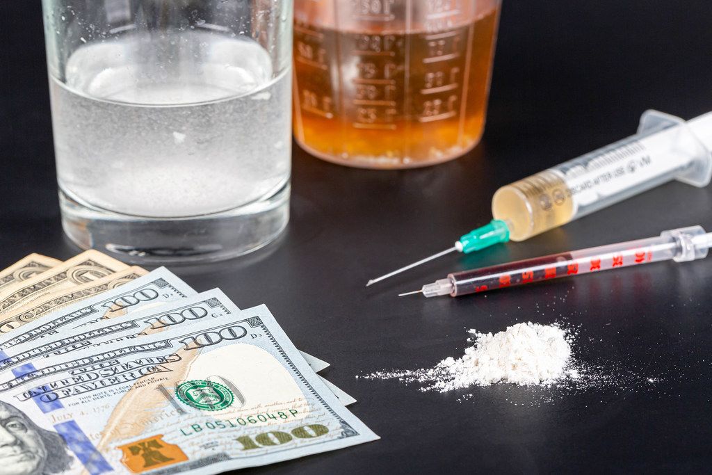 Deadly drugs and dollars on a black background