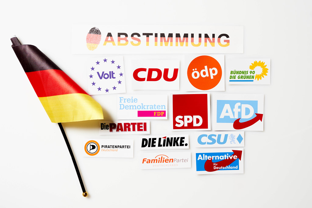 Deutsche Politik 2021 - Abstimmung in der Bundestagswahl. Parteilogos und deutsche Flagge
