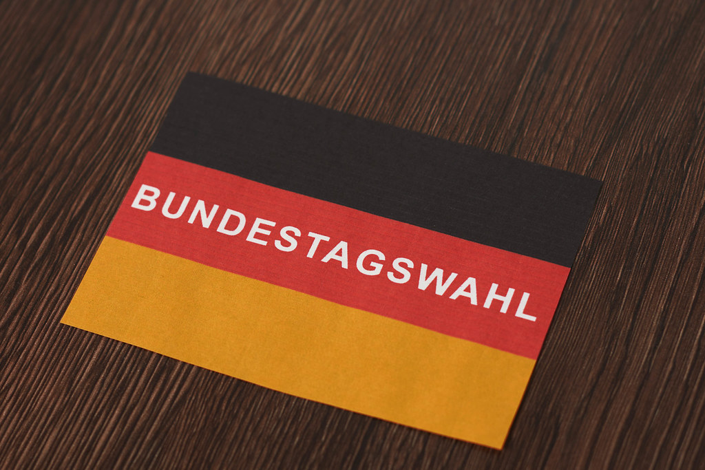Deutschland 2021: deutsche Flagge mit Schrift "Bundestagswahl" auf einem hölzernen Tisch