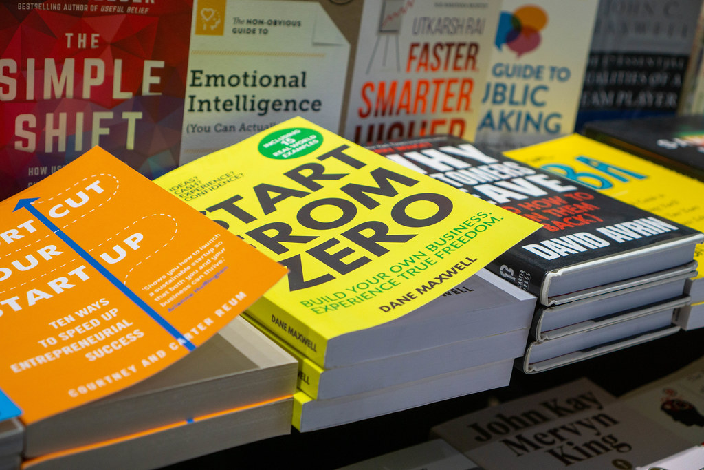 Different Business and Work Related Books such as Start from Zero and The Simple Shift on a Book Display in a Bookstore