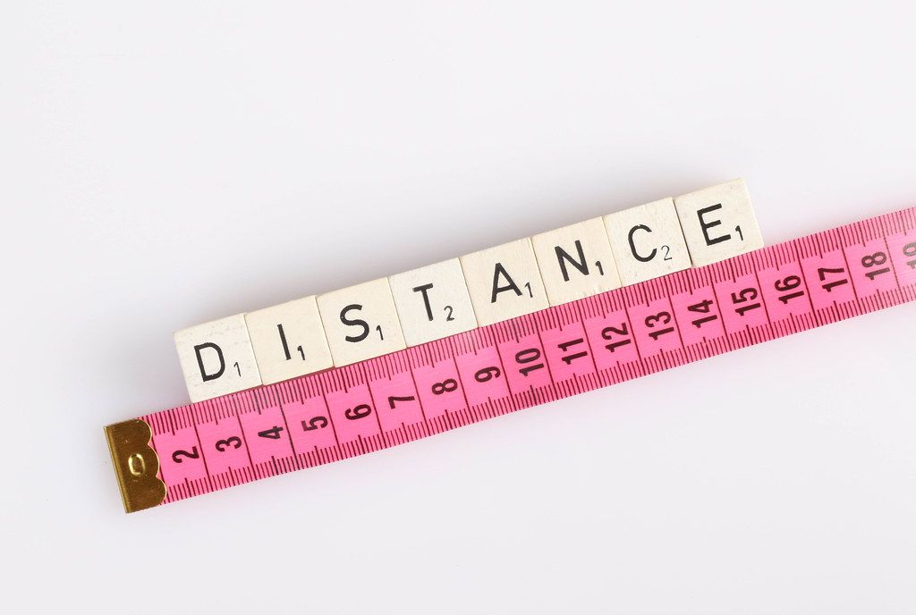 Distance text on wooden blocks with pink tape measure
