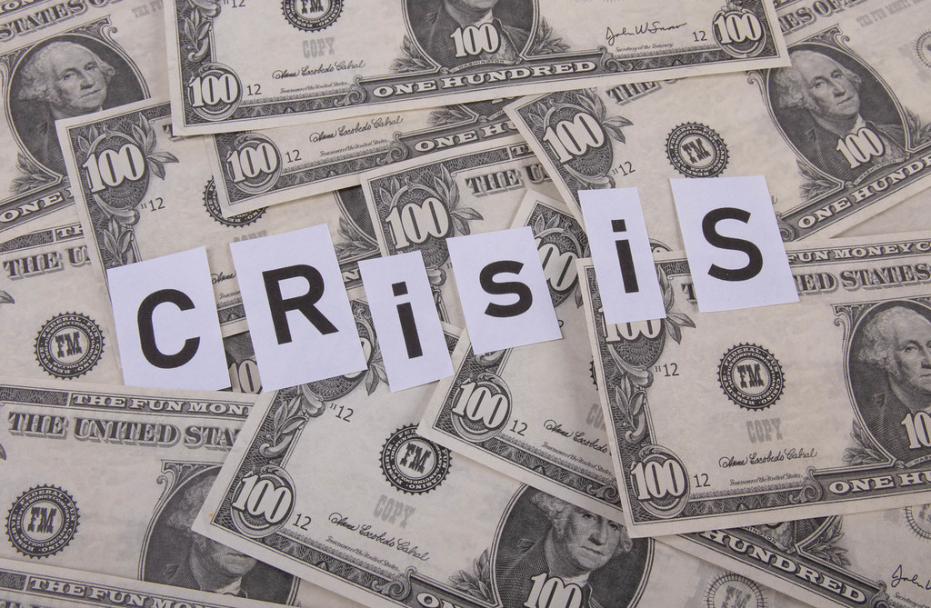 Dollar banknotes and Crisis text