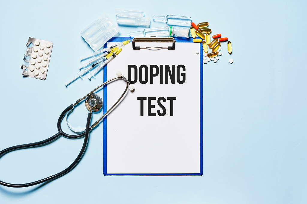Doping test - Medical stethoscope, pills, capsules and syringes with clipboard