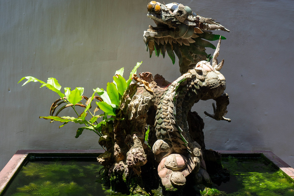 Drachen Statue mit Pflanzen in einem kleinen Teich in der Phuc Kien Pagode in Hoi An, Vietnam
