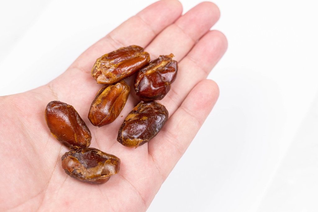 Dried Healthy Dates in the hand with copy space
