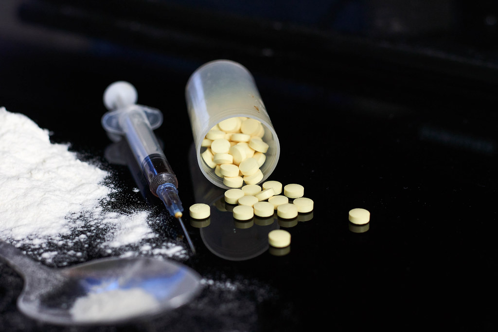 Drug addiction concept - pills, syringe and heroin