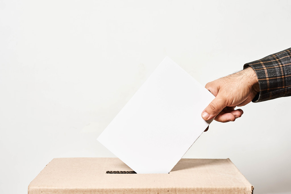 Election. Man throwing his vote into the ballot box