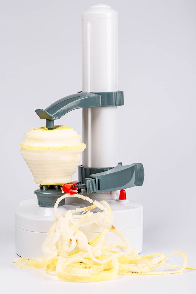 Electric device for peeling vegetables and fruits. Peeling an apple