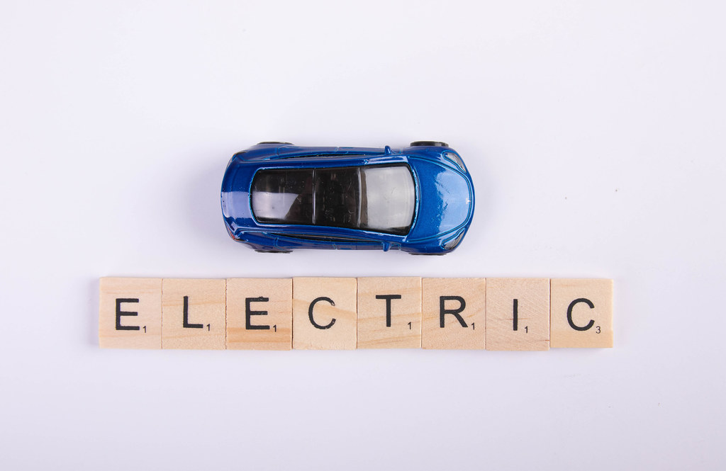 Electric toy car with Electric text on wooden blocks on white background