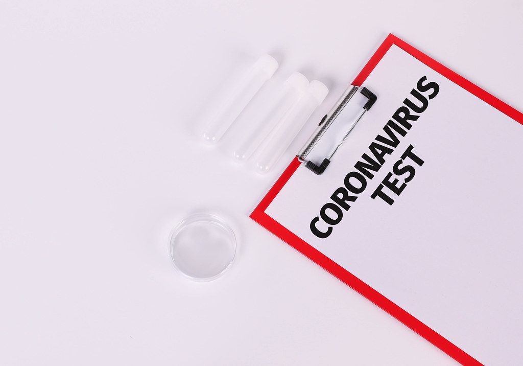 Empty test tubes and red clipboard with Coronavirus Test text on white background