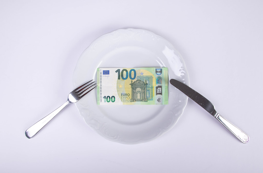 Euro money lying on the plate with fork and knife
