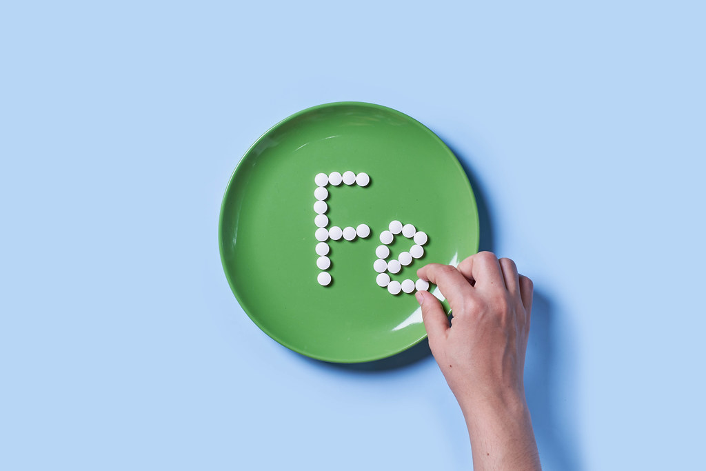 Fe Vitamin text made of tablets on plate