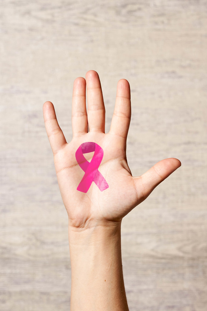 Female hand with painted pink awareness ribbon