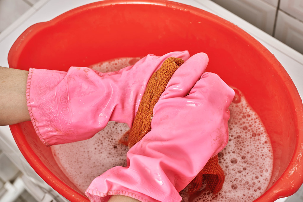 Female hands washing clothes in basin