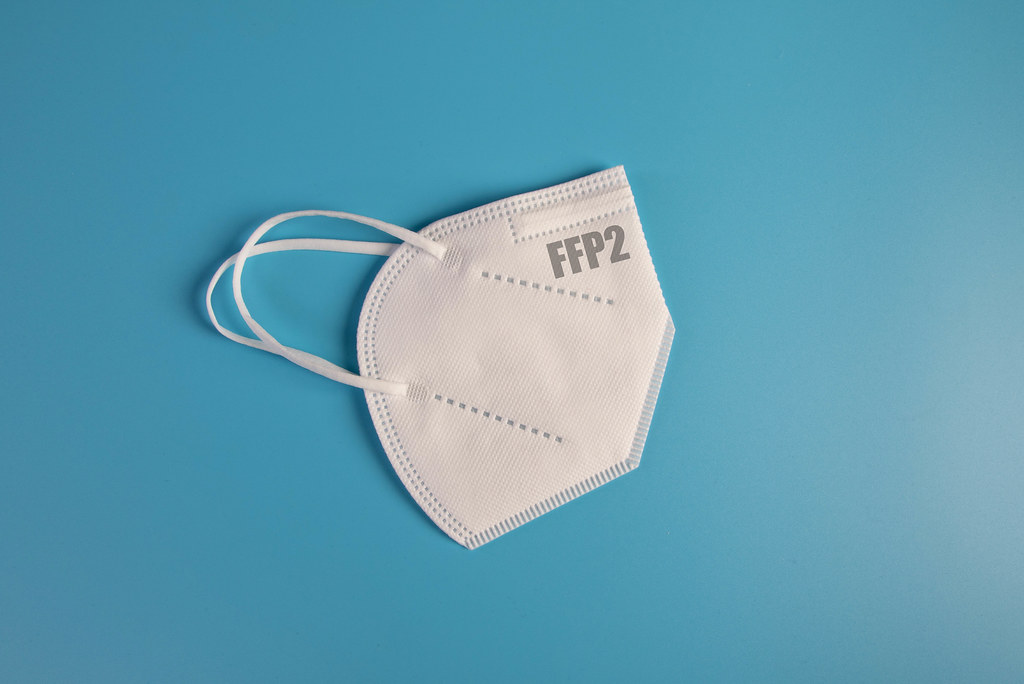 FFP2 medical face mask on blue background