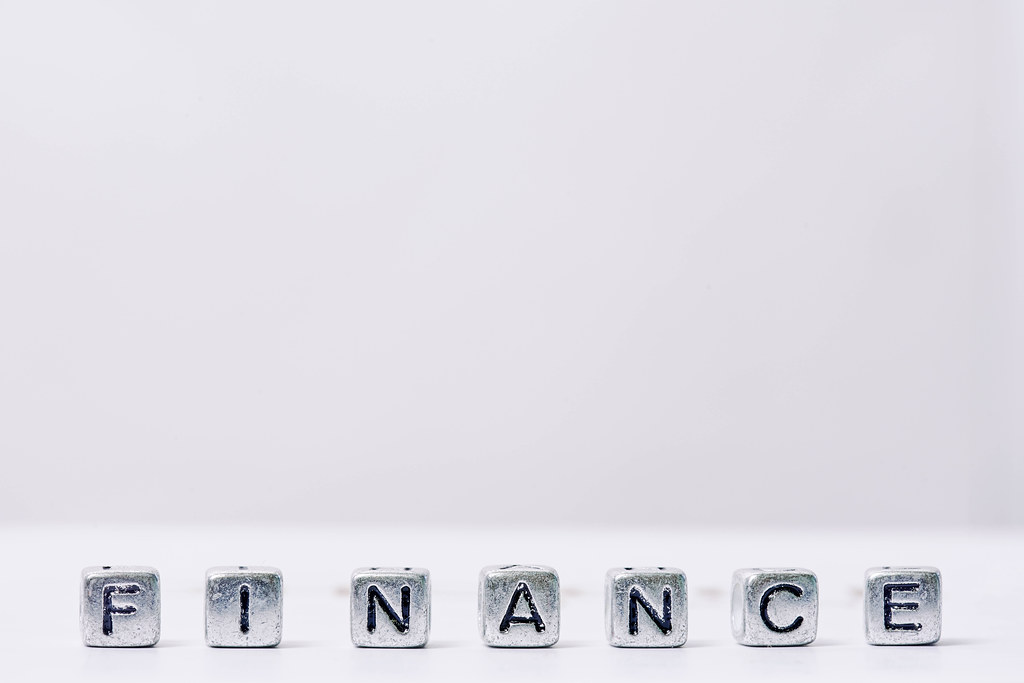 Finance word, made of miniature letter blocks on white background