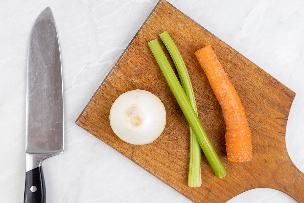 Flat lay above Carrot Celery and Onion on the wooden board