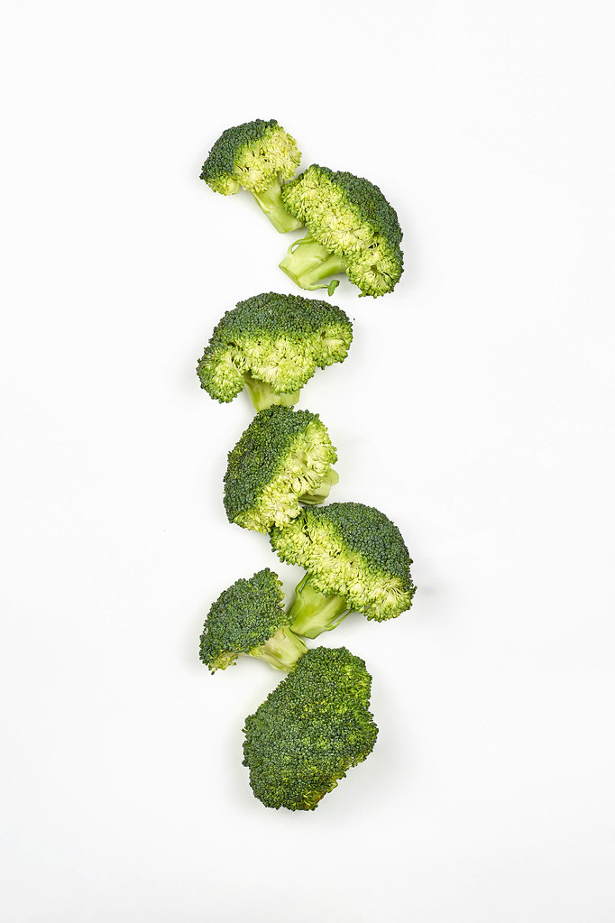 Flat lay composition with fresh green broccoli on white background