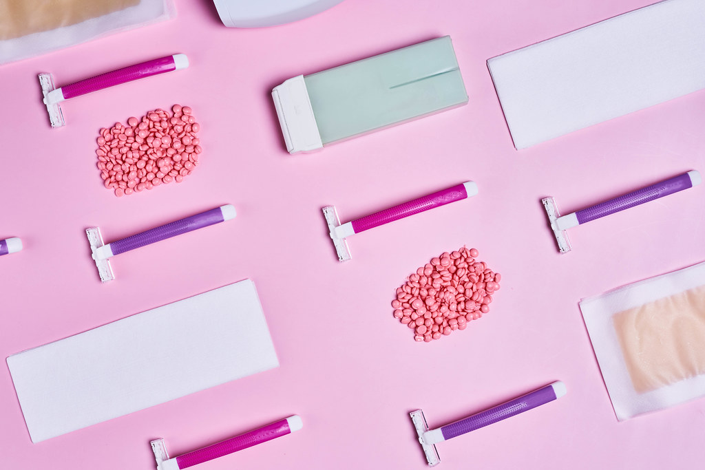 Flat lay set for epilation tools on pink background