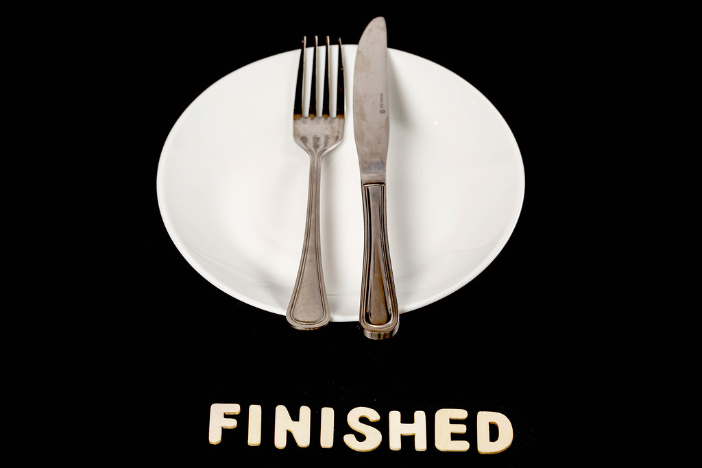 Fork and knife on a empty plate, dining etiquette concept, finishing meal